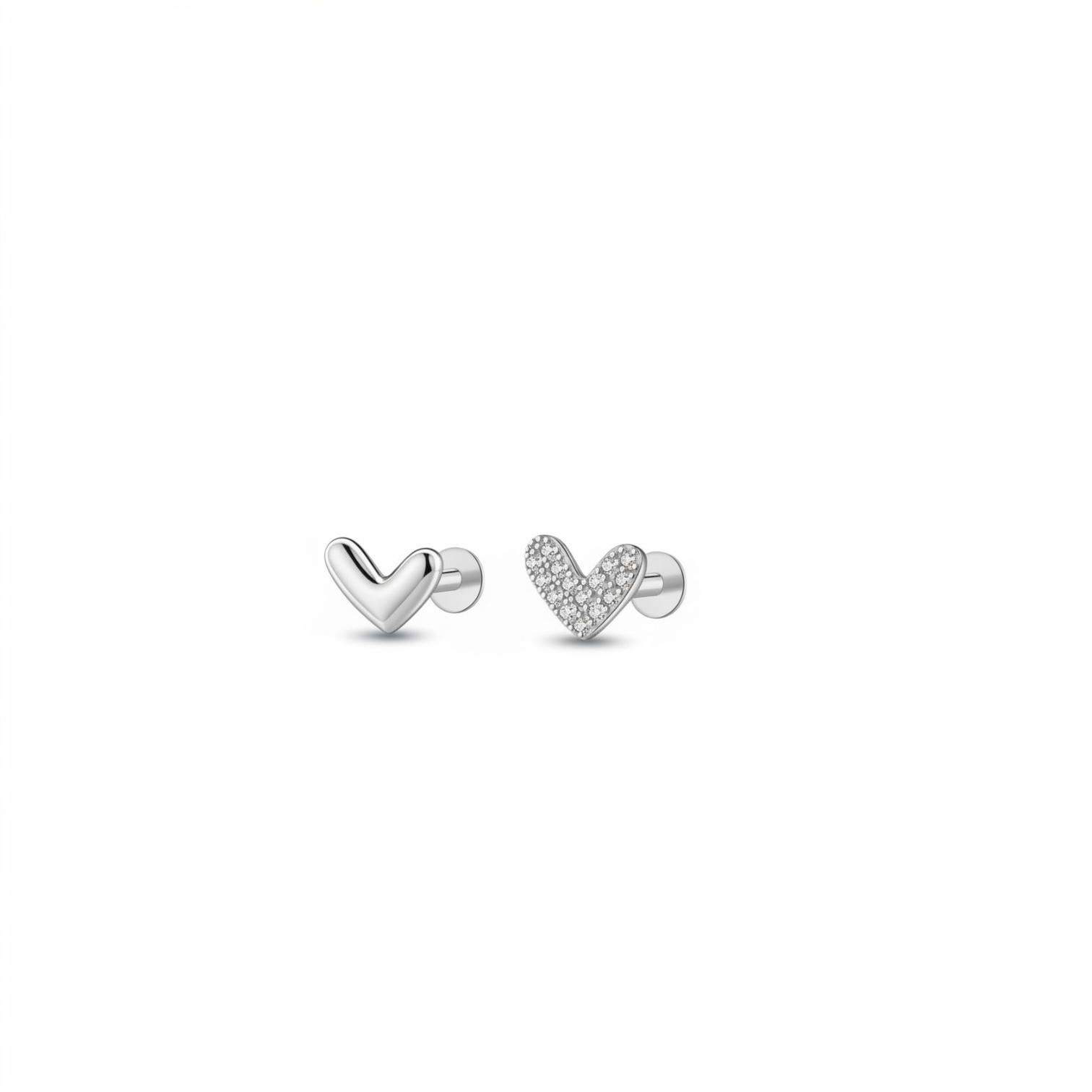 Close-up of a pair of 925 silver heart stud earrings for cartilage and lobe piercing – one polished plain heart and one pavé zircon heart on flat-back posts, minimalist hypoallergenic design.
