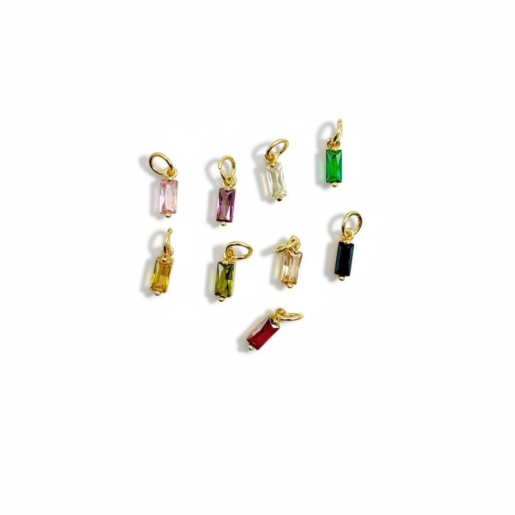 gold-plated baguette charms in multiple colors arranged on a white background