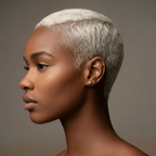 Side profile of a model with short platinum hair wearing a tiny 925 silver heart stud earring in the lobe, minimalist piercing jewelry by OMŌN Jewelry.