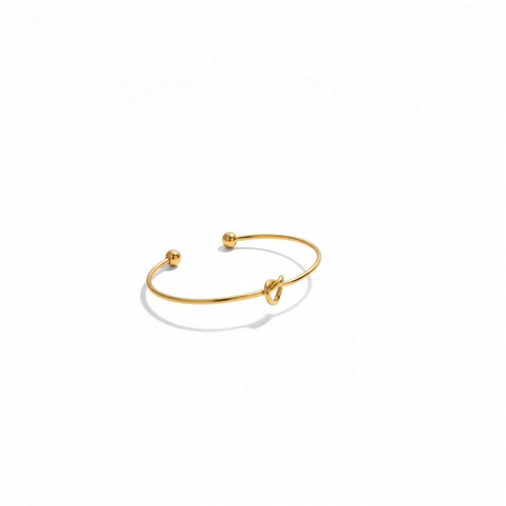 Gold knot cuff bracelet in 18K gold-plated stainless steel on a white background