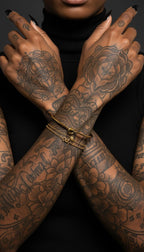 Model with crossed arms wearing a gold knot cuff bracelet on the wrist

Перевод: